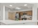 Open kitchen with wood cabinets, a stainless steel refrigerator, and a view of the living area at 1103 Hardwood Dr, Valrico, FL 33596