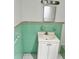 Classic bathroom with pastel green tile and a vanity with a sink and storage cabinet at 21077 Gertrude Ave, Port Charlotte, FL 33952