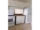 This kitchen offers white appliances, tiled floors, and ample cabinet space at 21077 Gertrude Ave, Port Charlotte, FL 33952
