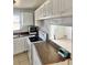 Traditional kitchen featuring white cabinets, tile flooring, and brown countertops at 21077 Gertrude Ave, Port Charlotte, FL 33952