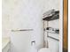 Compact bathroom with built in shelves for towels, updated fixtures, and floral wallpaper at 2700 Bayshore Blvd # 3210, Dunedin, FL 34698