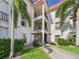 Multi-story building exterior with balconies, lush landscaping, and a well-maintained facade, showcasing curb appeal at 2700 Bayshore Blvd # 3210, Dunedin, FL 34698