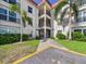 Attractive condo building with balconies, manicured landscaping, and sidewalk entrance at 2700 Bayshore Blvd # 3210, Dunedin, FL 34698