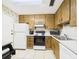 Efficient kitchen with wooden cabinets, white appliances, and tile flooring at 2700 Bayshore Blvd # 3210, Dunedin, FL 34698