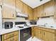 Kitchen area features white appliances and ample retro wood cabinetry at 2700 Bayshore Blvd # 3210, Dunedin, FL 34698