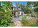 Home backyard with a stone pathway, lush foliage and a patio area with a pergola at 1007 N Wheeler St, Plant City, FL 33563