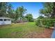 A spacious backyard with green lawn, garden beds, and a white storage shed at 1007 N Wheeler St, Plant City, FL 33563