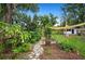 Landscaped backyard with lush greenery, stone pathway, and a charming shed, perfect for outdoor relaxation at 1007 N Wheeler St, Plant City, FL 33563