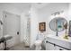 Well lit bathroom featuring gray tiled floors, white vanity, and shower with patterned shower curtain at 1007 N Wheeler St, Plant City, FL 33563