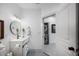Charming bathroom with modern vanity, round mirror, and convenient access to a laundry area at 1007 N Wheeler St, Plant City, FL 33563