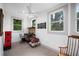 Bright bedroom featuring three windows, wood floors, and simple furniture at 1007 N Wheeler St, Plant City, FL 33563