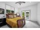 Bright bedroom with french doors leading to the backyard and a plush yellow bedspread at 1007 N Wheeler St, Plant City, FL 33563