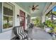 Inviting front porch with a black and white rug, wicker furniture, and ceiling fan at 1007 N Wheeler St, Plant City, FL 33563