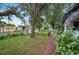 Lush front yard with mature trees, white picket fence, and pergola at 1007 N Wheeler St, Plant City, FL 33563