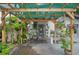 Covered patio with a dining area, lush plants, and cozy lighting for outdoor gatherings at 1007 N Wheeler St, Plant City, FL 33563