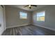 Well-lit bedroom highlighting updated flooring, neutral paint, a ceiling fan, and large windows at 1735 Council Dr, Sun City Center, FL 33573