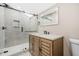 Modern bathroom with a glass enclosed shower, decorative tile flooring, and a vanity with a lighted mirror at 3620 E Tampa Cir, Tampa, FL 33629