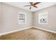 Bedroom features laminate floors, a ceiling fan, two windows, and a calming paint at 3620 E Tampa Cir, Tampa, FL 33629
