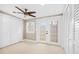 Bedroom with a ceiling fan, a window, and double doors to a small porch at 3620 E Tampa Cir, Tampa, FL 33629