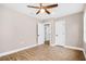 Spacious bedroom with laminate floors, a ceiling fan, and multiple doorways for easy access at 3620 E Tampa Cir, Tampa, FL 33629