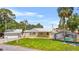 Charming home with metal roof, screened pool, and covered porch, set on a green lawn at 3620 E Tampa Cir, Tampa, FL 33629