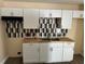 A well-lit kitchen showcases new white cabinets, modern backsplash, and updated countertops at 3620 E Tampa Cir, Tampa, FL 33629