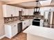 Bright kitchen featuring white cabinets, an island, stainless steel appliances, and modern lighting at 3620 E Tampa Cir, Tampa, FL 33629