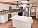 Open-concept kitchen with stainless steel appliances, white cabinetry, island, and stylish backsplash at 3620 E Tampa Cir, Tampa, FL 33629
