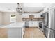 Modern kitchen features stainless steel appliances, a white island, and elegant pendant lighting at 3620 E Tampa Cir, Tampa, FL 33629