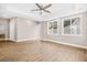 Large living room with LVP flooring, tray ceilings with fan, and an abundance of natural light from large windows at 3620 E Tampa Cir, Tampa, FL 33629