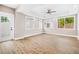Spacious living room featuring LVP flooring, abundant natural light from large windows, and a ceiling fan at 3620 E Tampa Cir, Tampa, FL 33629