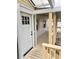 Covered porch featuring a white door with glass panes and painted wood flooring at 3620 E Tampa Cir, Tampa, FL 33629