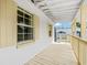 Covered side porch featuring wooden flooring and railings, providing an inviting outdoor area at 3620 E Tampa Cir, Tampa, FL 33629