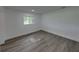 A bright bedroom features gray laminate floors and a window view at 602 E Laura St, Plant City, FL 33563
