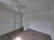 A renovated bedroom featuring modern flooring, white walls, and updated ceiling fan at 602 E Laura St, Plant City, FL 33563