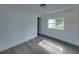 A bright bedroom features gray laminate floors and a view of outside at 602 E Laura St, Plant City, FL 33563
