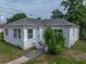Charming white house with a blue door and a well-kept yard, creating a welcoming curb appeal at 602 E Laura St, Plant City, FL 33563