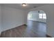 Bright living room with modern flooring and white walls, leading to another room through a cased opening at 602 E Laura St, Plant City, FL 33563