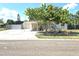 Charming single-story home featuring a two-car garage, carport, and landscaped front yard with mature trees at 7943 Woodvine Cir, Tampa, FL 33615