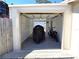 An open, white garage with a motorcycle and motor scooter parked inside, featuring bright lighting at 7943 Woodvine Cir, Tampa, FL 33615