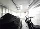 View of an open garage interior with a motorcycle covered by a tarp and an e-bike at 7943 Woodvine Cir, Tampa, FL 33615