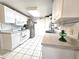 Bright white kitchen features updated cabinets, countertop, tiled floor and stainless steel appliances at 7943 Woodvine Cir, Tampa, FL 33615