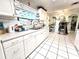 Well-lit kitchen featuring white cabinets, tiled floors, and open countertop space at 7943 Woodvine Cir, Tampa, FL 33615