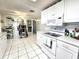 Bright kitchen featuring white cabinets, a range, and tiled flooring at 7943 Woodvine Cir, Tampa, FL 33615