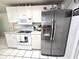 Modern kitchen featuring stainless steel appliances, white cabinets, and tiled backsplash at 7943 Woodvine Cir, Tampa, FL 33615
