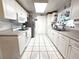 Bright white kitchen features updated cabinets, countertop, tiled floor and stainless steel appliances at 7943 Woodvine Cir, Tampa, FL 33615