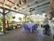 Covered patio with ceiling fan, outdoor dining table and fenced-in area with hanging plants and BBQ grill at 7943 Woodvine Cir, Tampa, FL 33615