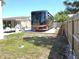 View of the RV with parking area next to house and fence at 7943 Woodvine Cir, Tampa, FL 33615