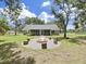 The spacious backyard offers a cozy brick fire pit with wood stump seating and serene landscape at 106 Corbett Rd, Lithia, FL 33547