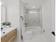 Bright bathroom showcasing a single sink vanity, black hardware, and a bathtub with marble-look tile at 106 Corbett Rd, Lithia, FL 33547